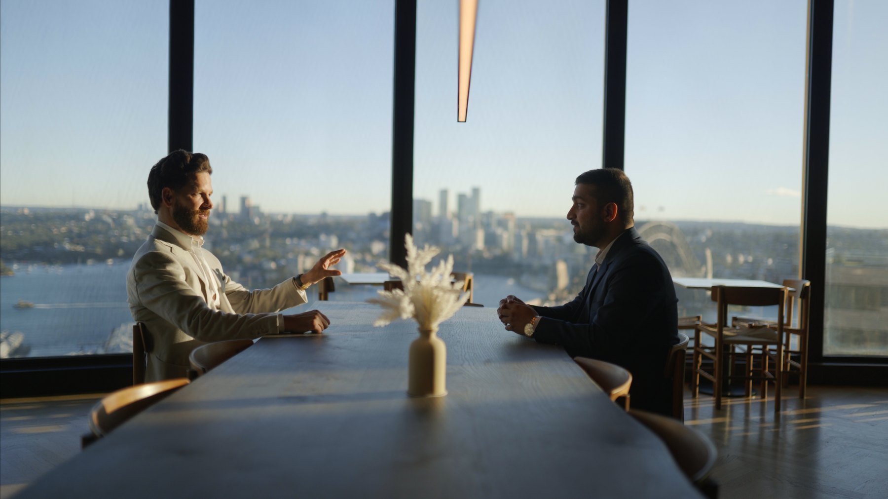 Matt Harris and Lakshay Chandan meeting in the Lighthouse Accounting boardroom in Sydney, with Sydney Harbour through the windows